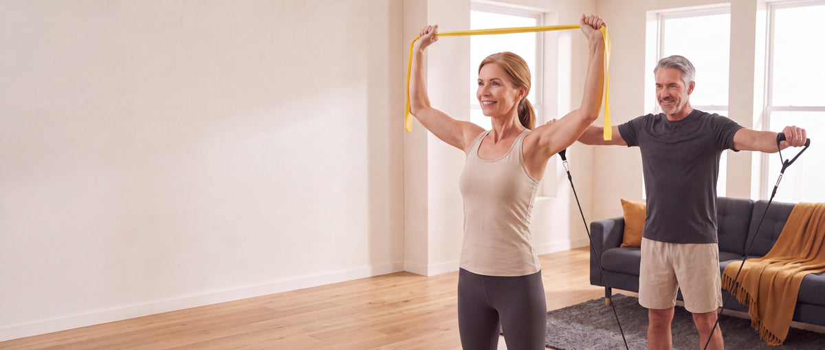 A couple in their fifties training with resistance bands at home